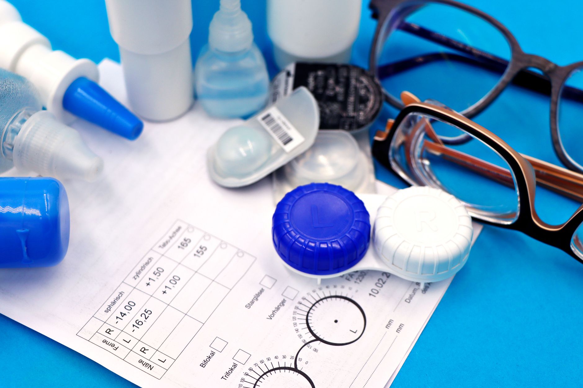 Close-up of contact lenses, case, and eyeglasses on a prescription form. — illustrating When Are Polarised Lenses a Bad Idea? A Real Answer