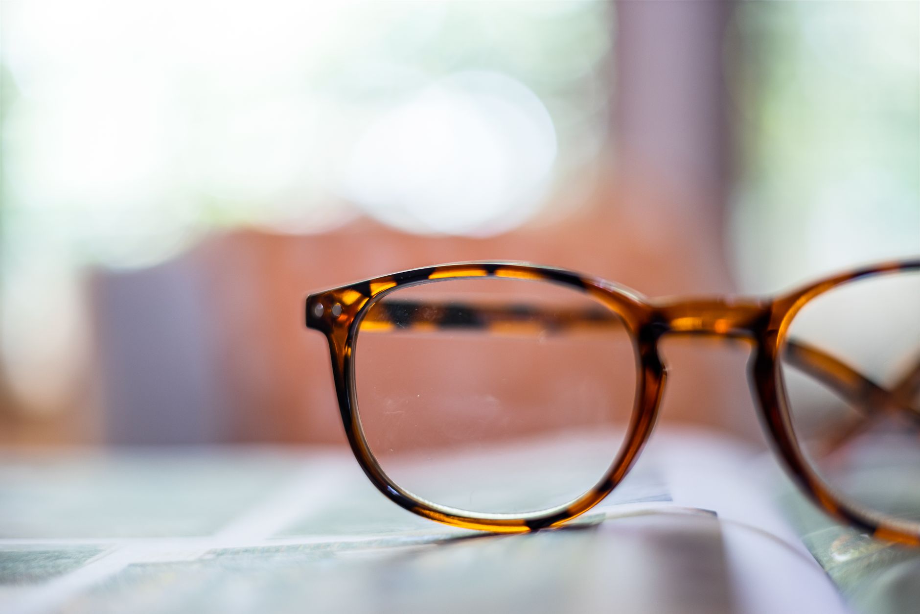 Detailed close-up of fashion-forward tortoiseshell eyeglasses on a blurred background. — illustrating Where Did the Tortoiseshell Pattern on Glasses Come From?