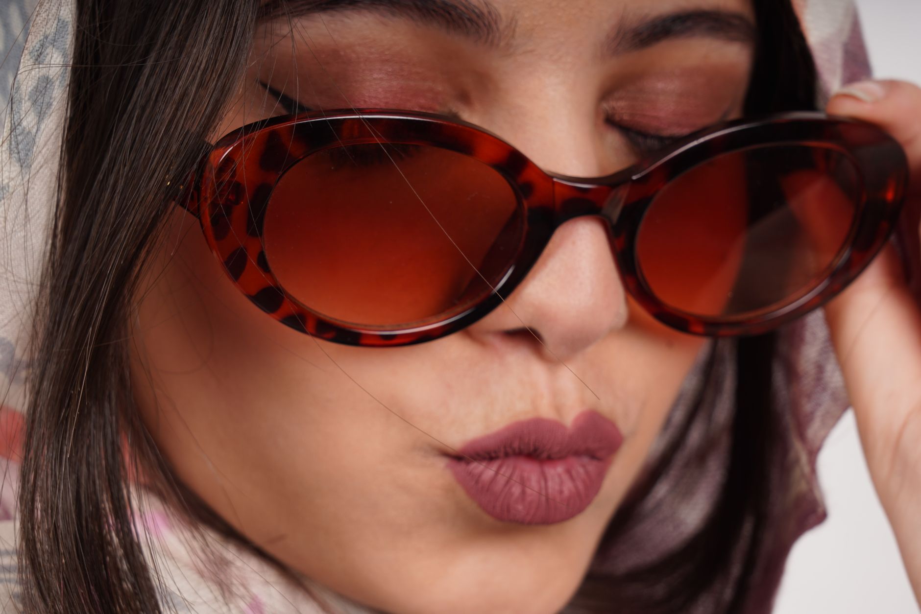 Fashionable close-up of an adult woman wearing stylish sunglasses with a trendy expression. — illustrating Why Do 1950s Eyewear Shapes Keep Coming Back?